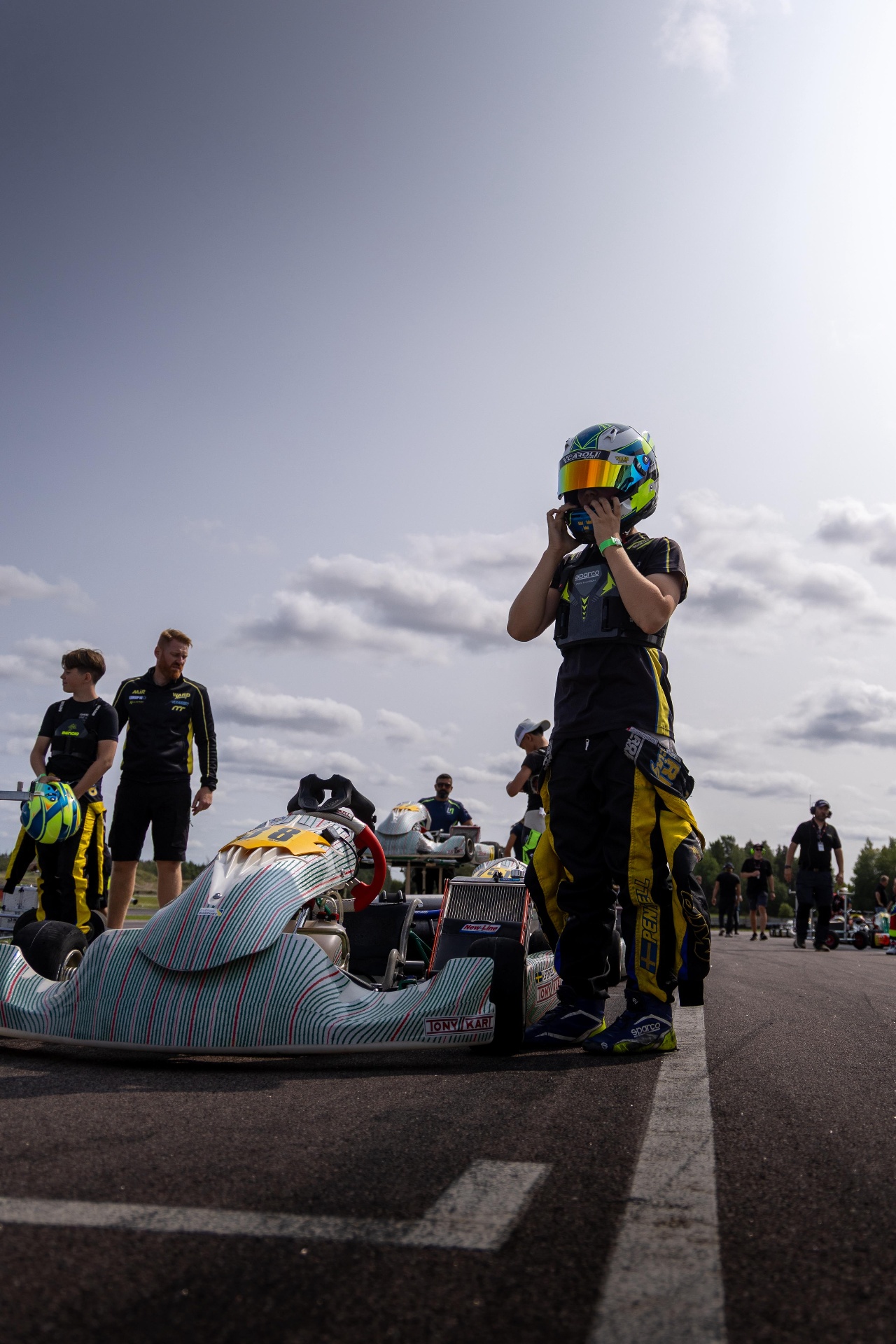 Kevin Pentell strapping his helmet on under a wide Swedish sky
